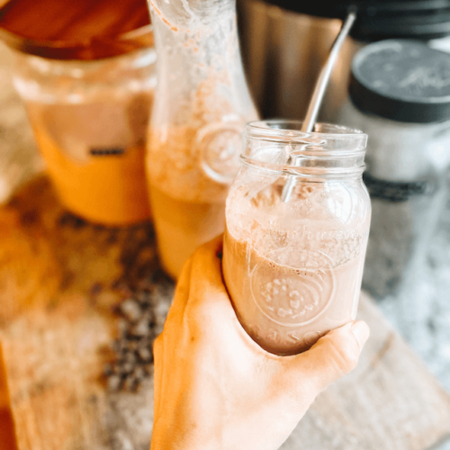 A hand holding a glass of milk